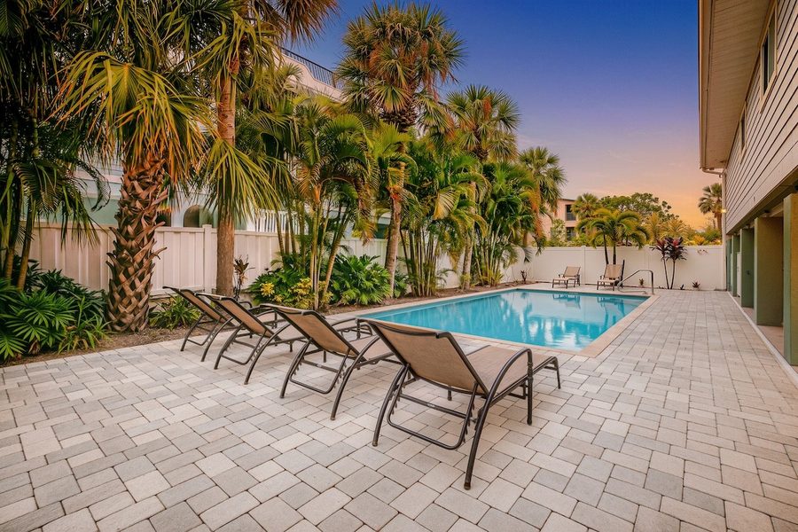 Pool courtyard at dusk lined with palms
