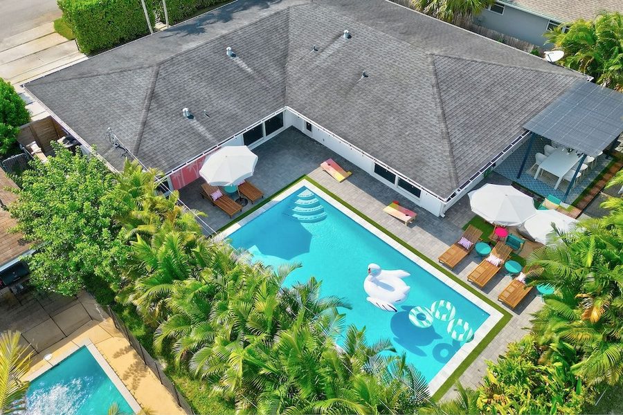 Backyard pool at dusk with string lights and palms