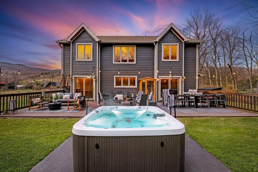 Mountain lodge at dusk with hot tub in the foreground