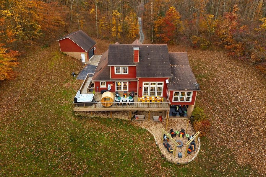 Aerial view of red farmhouse beside pond