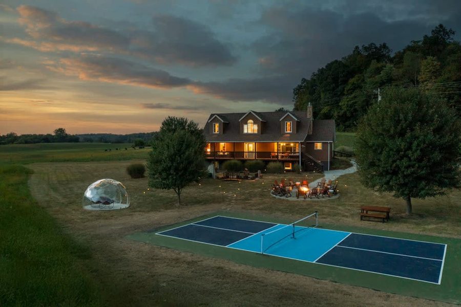 Aerial view of house at dusk with pickleball court